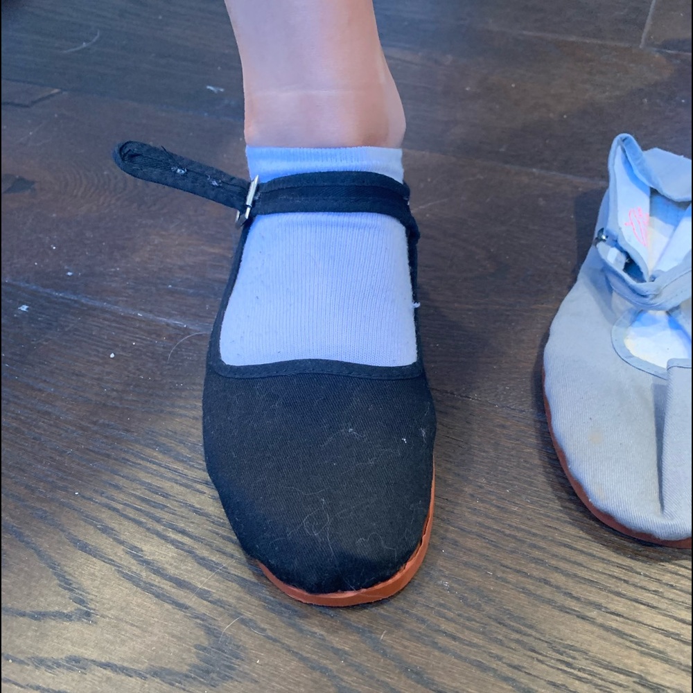 Black and grey slip on strap shoes.